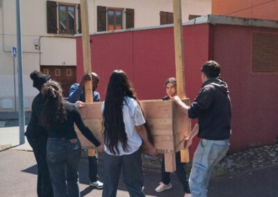 Participants portant les bacs pour les installer sur le parvis de la maison des associations